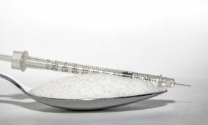 seringue et cuillère remplie de sucre
